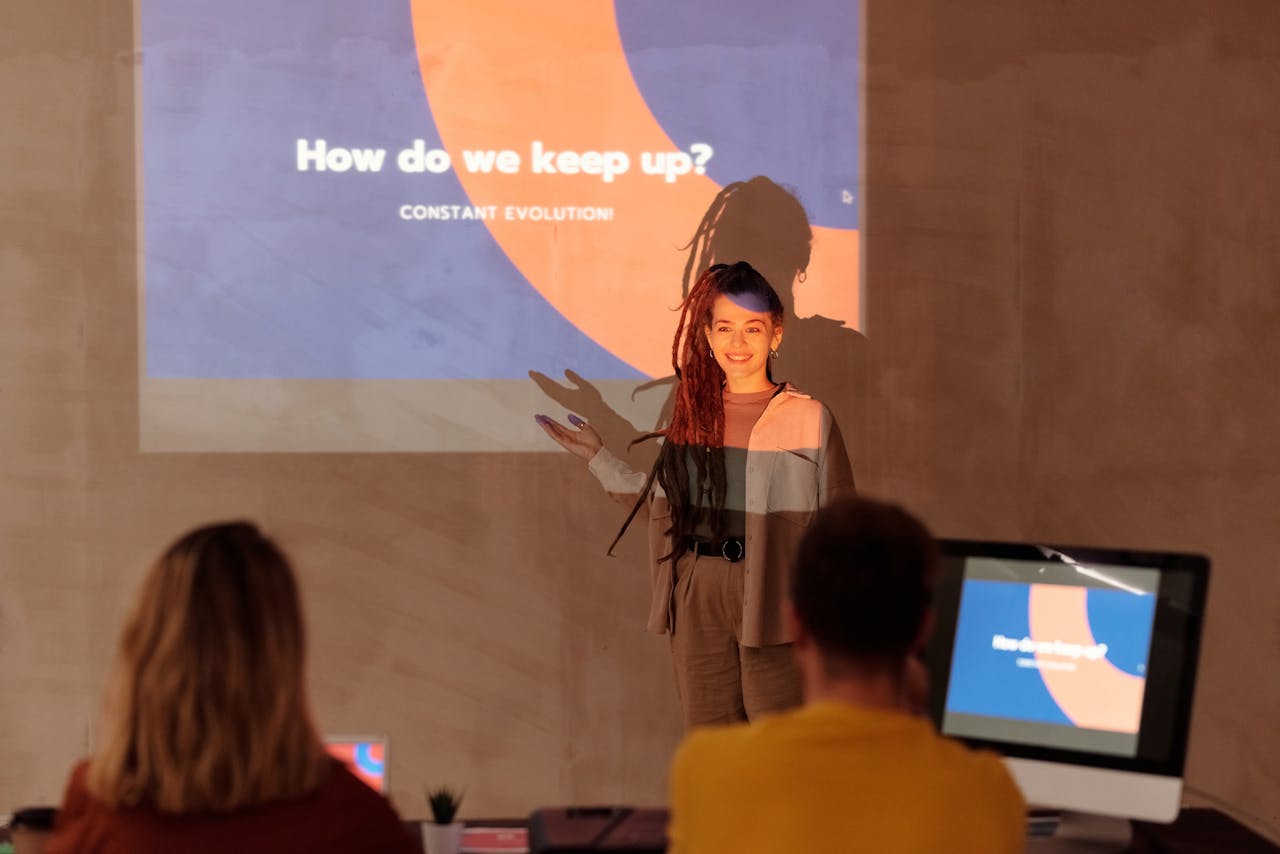 Business meeting featuring a presenter with a projected slide and engaged audience.